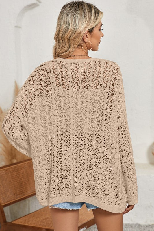 Woman wearing a beige knitted cardigan in a home setting