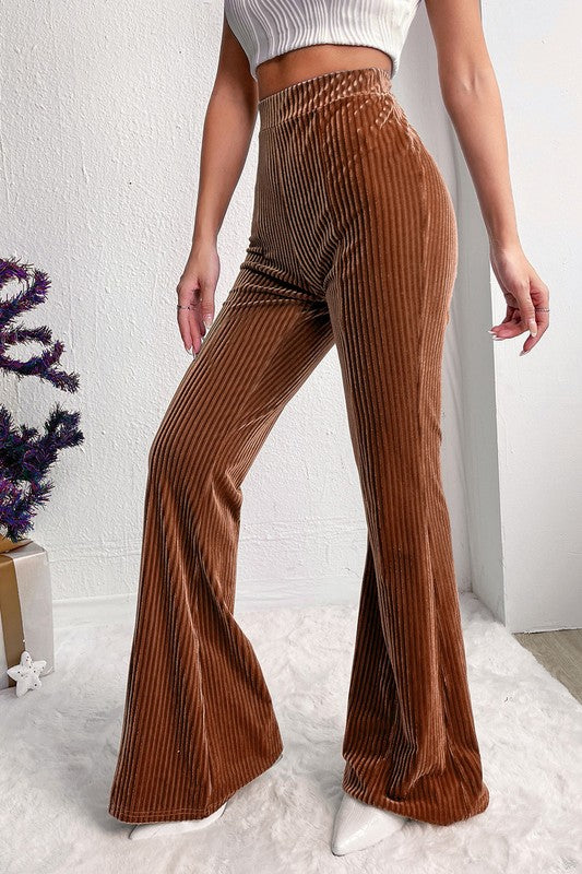 Brown ribbed flared pants worn by a person on a white background