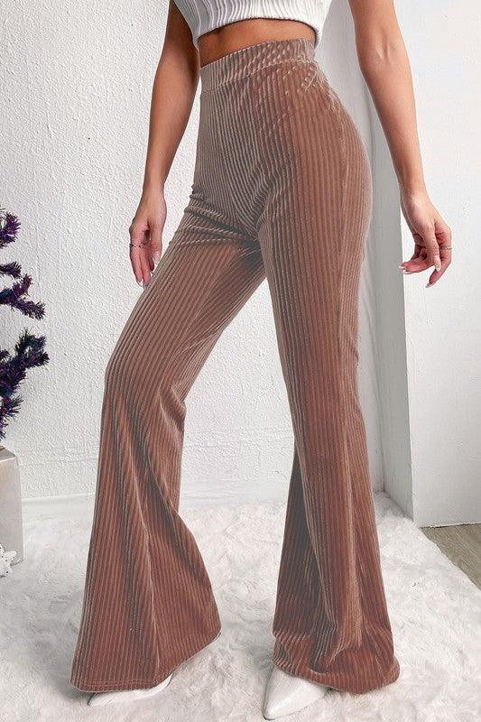 Brown ribbed flared pants worn by a person on a white background