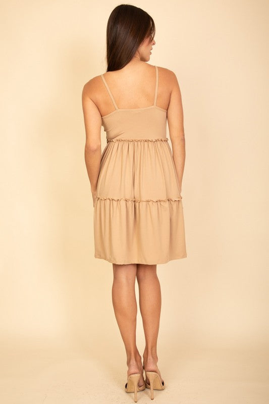 Woman wearing a beige dress against a beige background