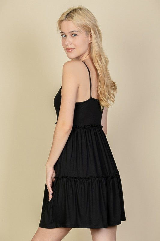 Woman wearing a black dress against a beige background
