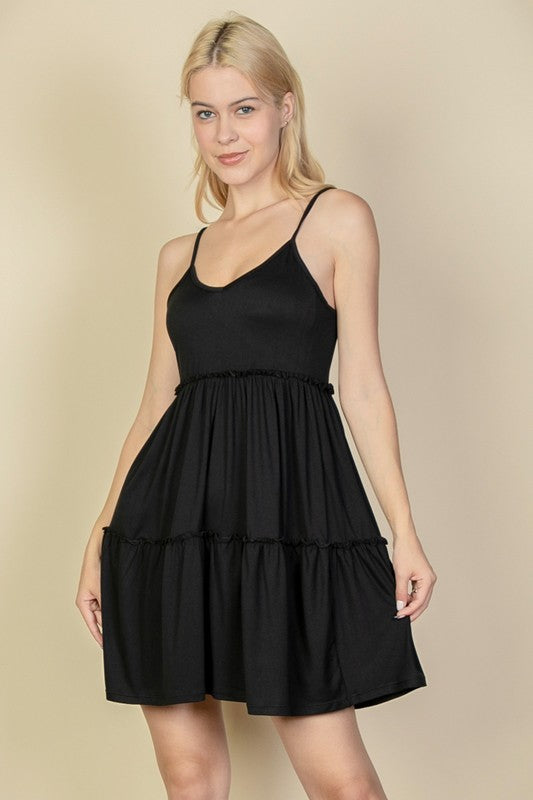 Woman wearing a black dress against a beige background