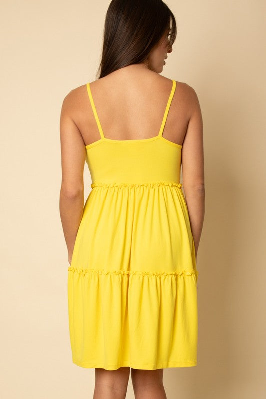 Yellow dress worn by a person on a beige background