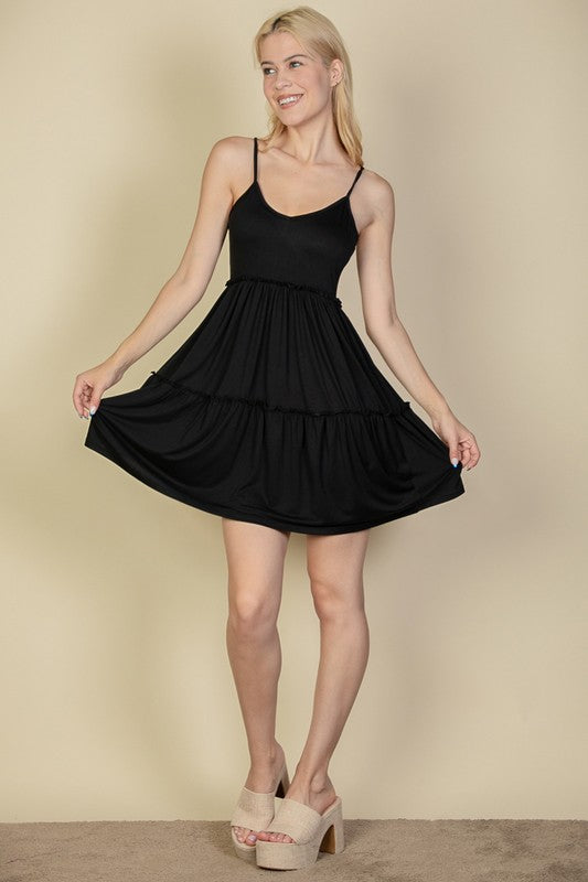 Woman wearing a black dress against a beige background