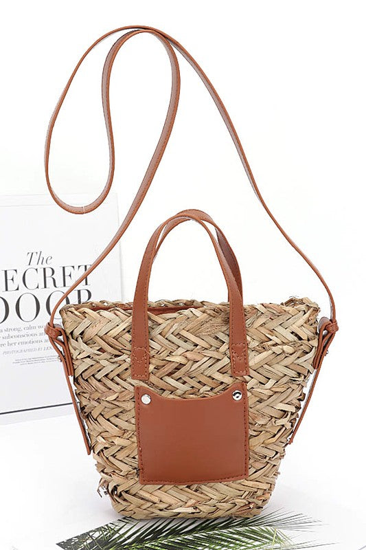 Woven handbag with brown leather accents on a white background