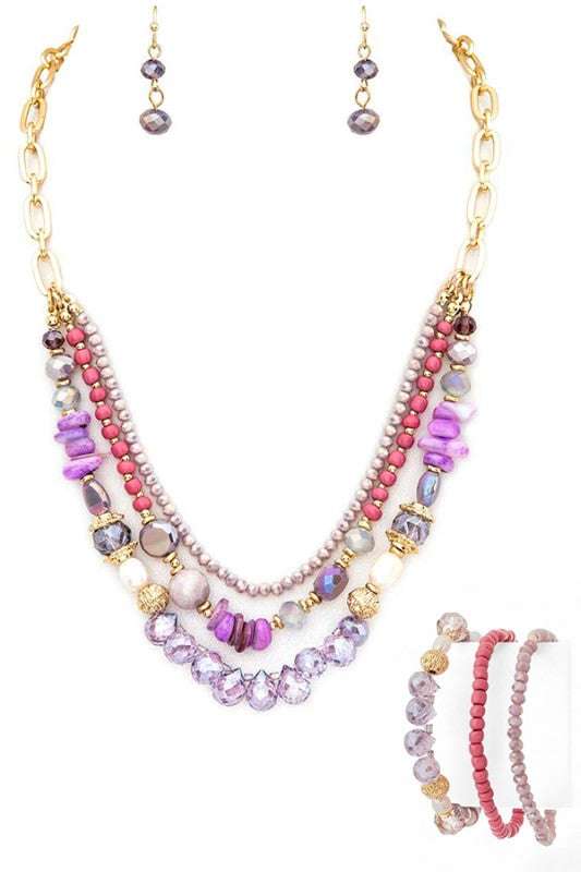 Multistrand beaded necklace with pink, purple, and gold beads on a white background.