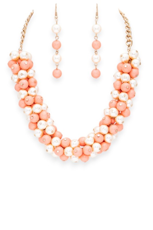 Necklace and earrings set with coral and pearl beads on a white background