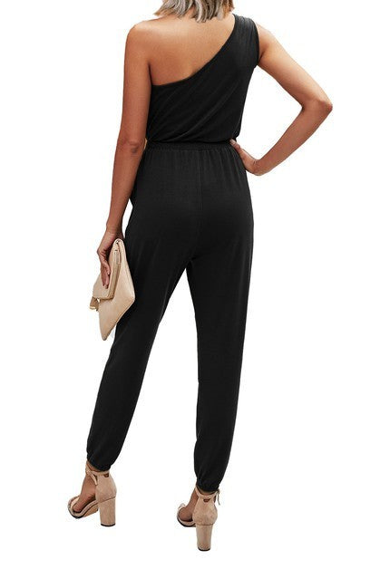Black one-shoulder jumpsuit worn by a person on a white background