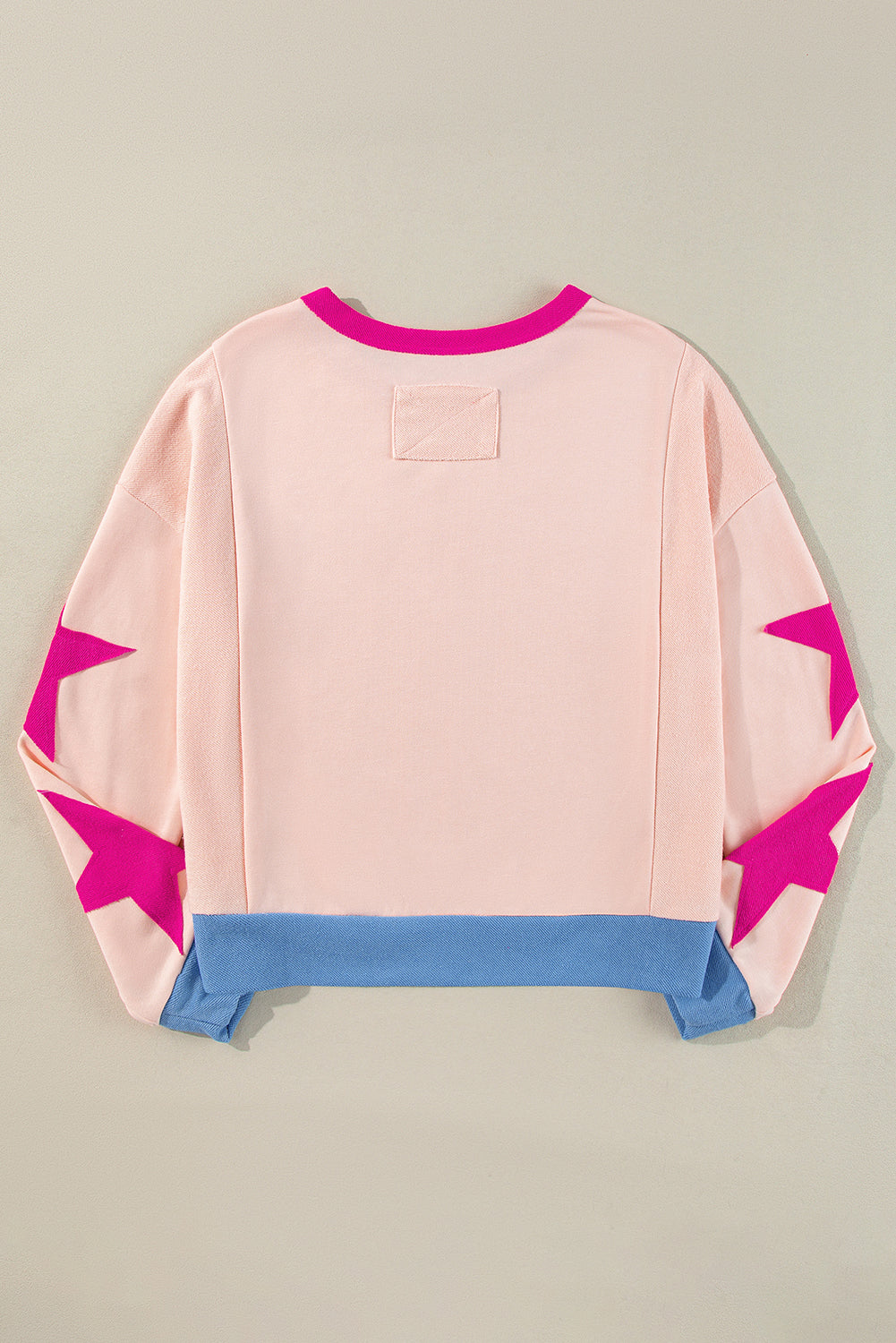 Pink sweater with star designs on a beige background