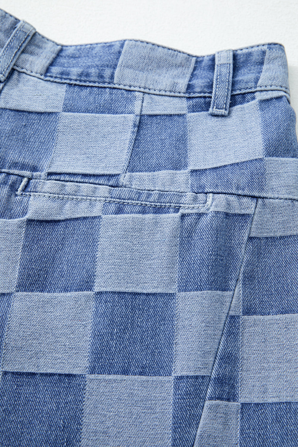 Close-up of a blue checkered fabric with a patterned texture.