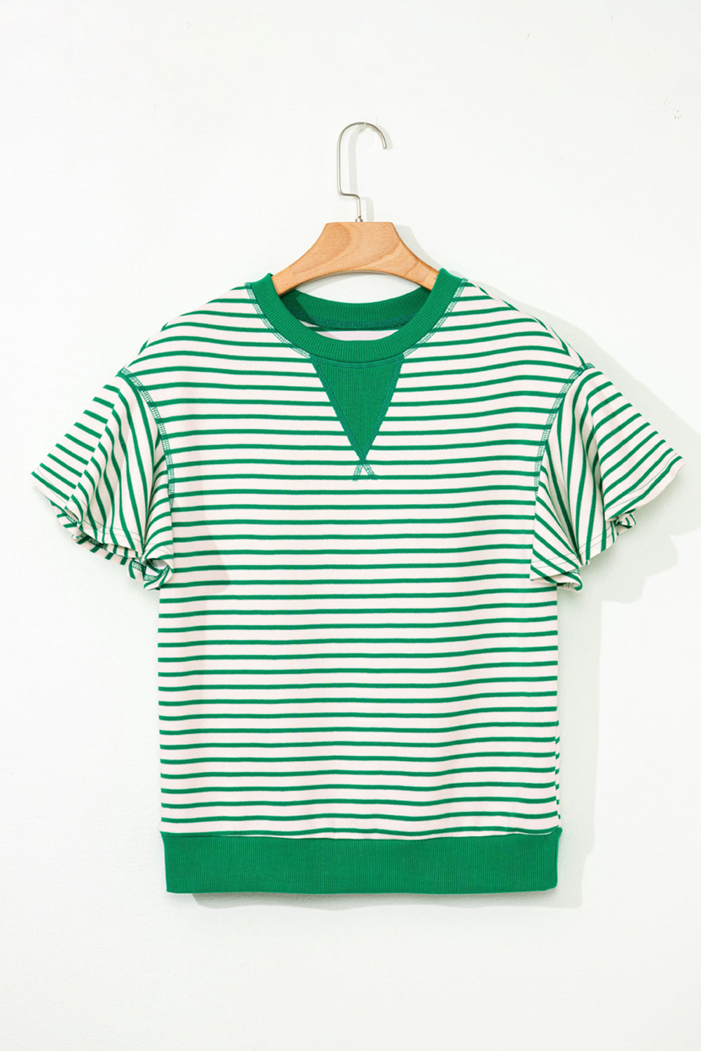 Green and white striped shirt on a wooden hanger against a white background