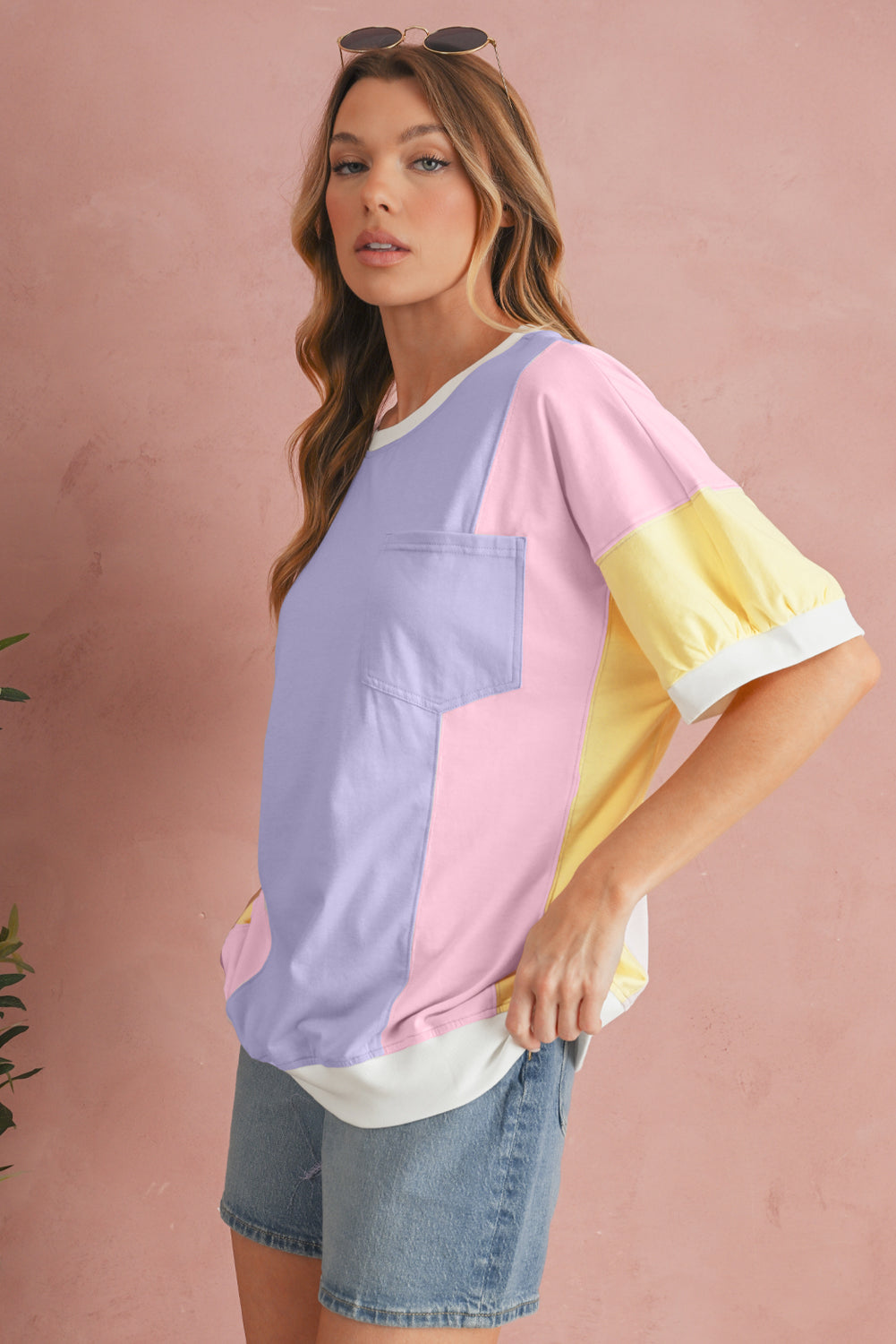 Woman wearing a colorful oversized shirt against a pink background