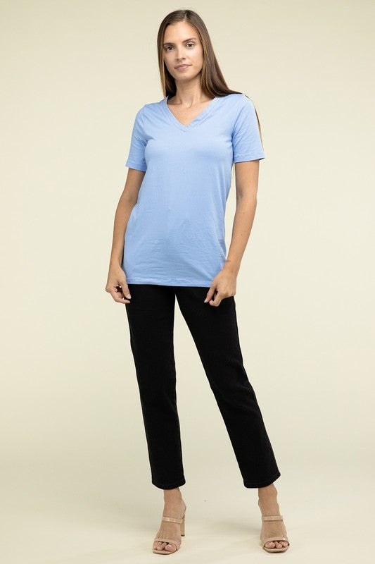 Woman wearing a light blue t-shirt and black pants on a beige background