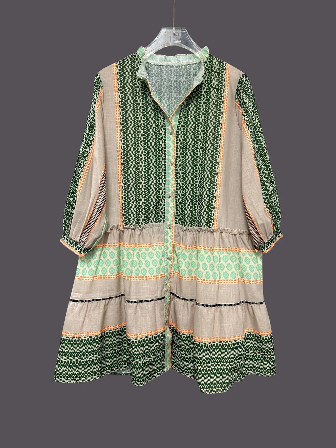 Traditional outfit with green and beige patterns on a gray background
