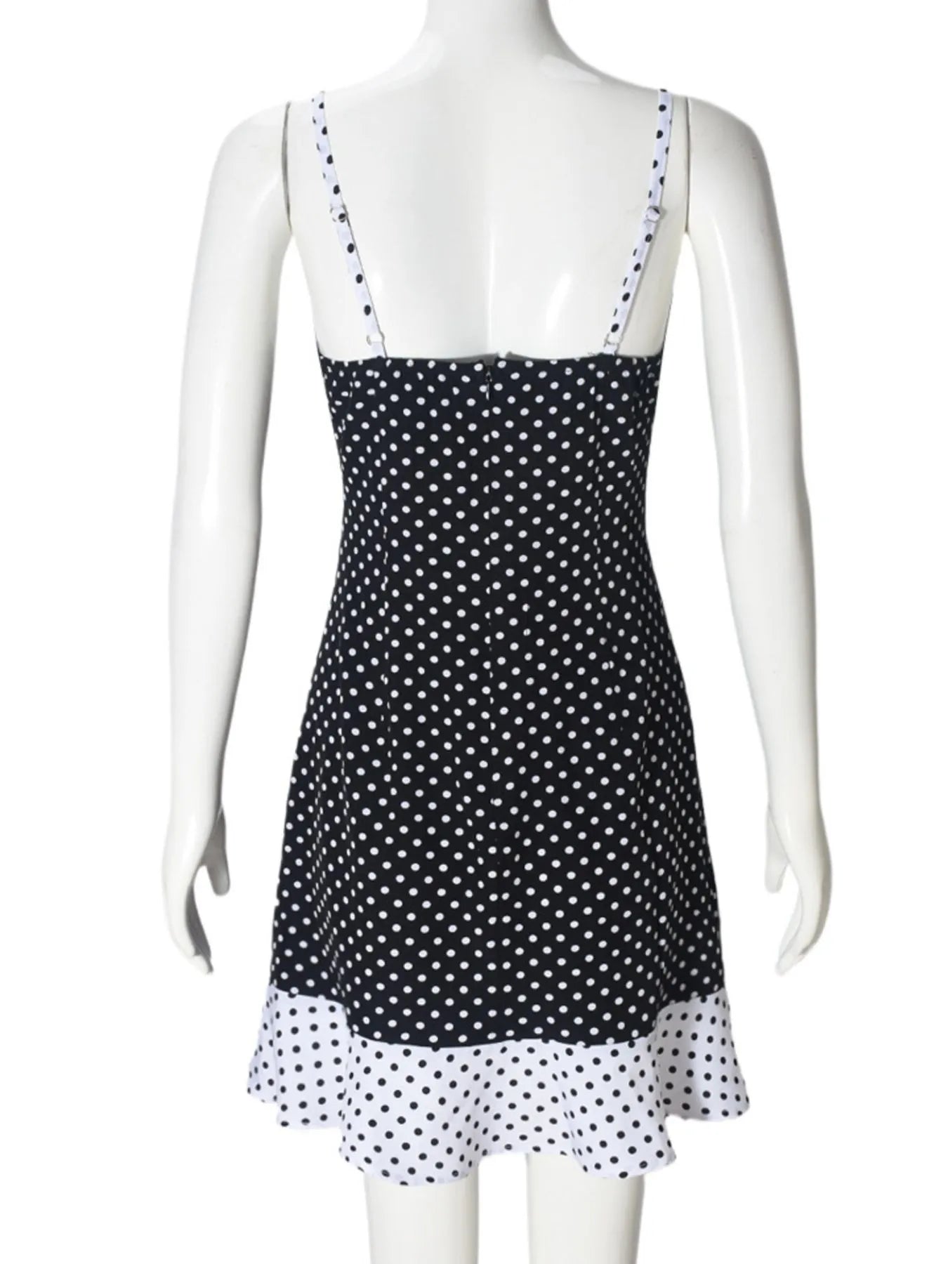 Black and white polka dot dress on a mannequin against a white background