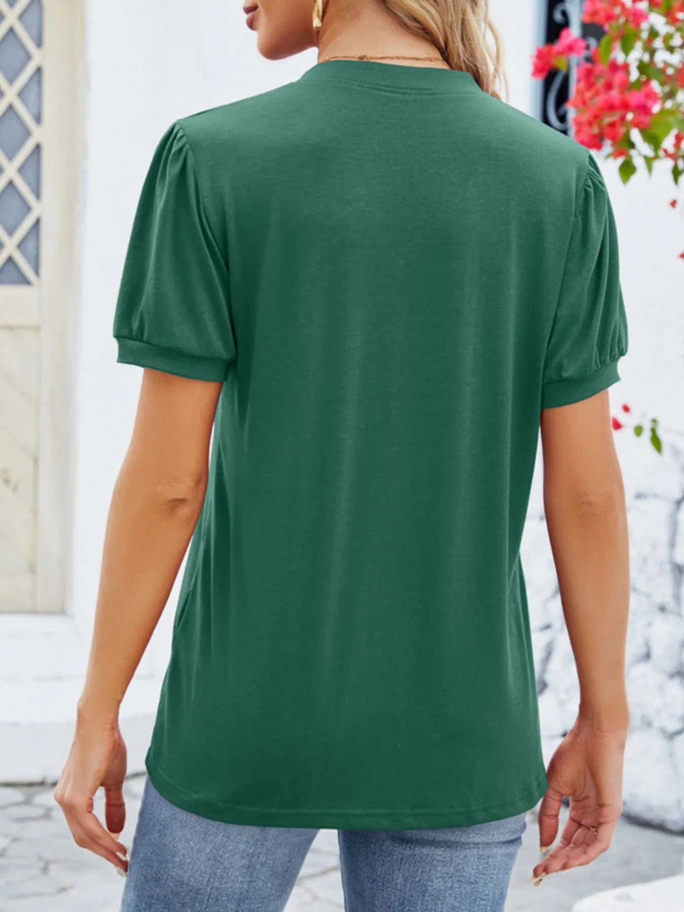 Person wearing a green t-shirt with a blurred background