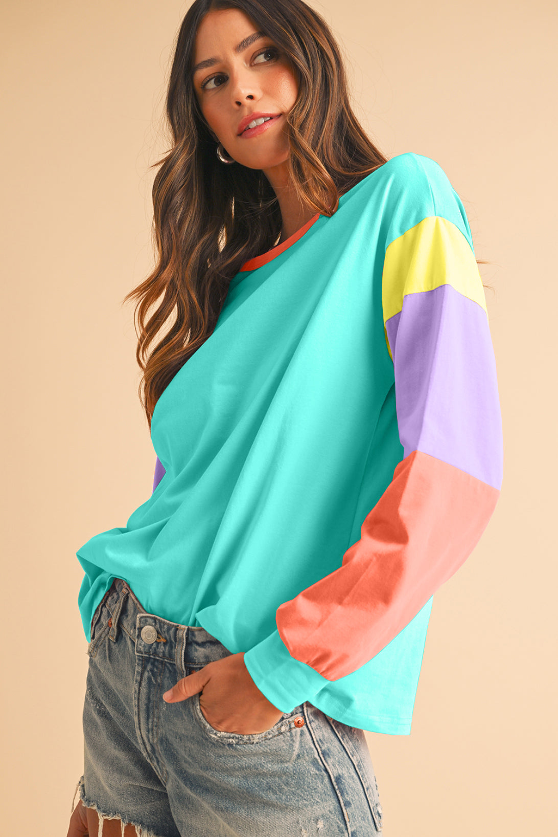 Woman wearing a colorful striped shirt against a beige background