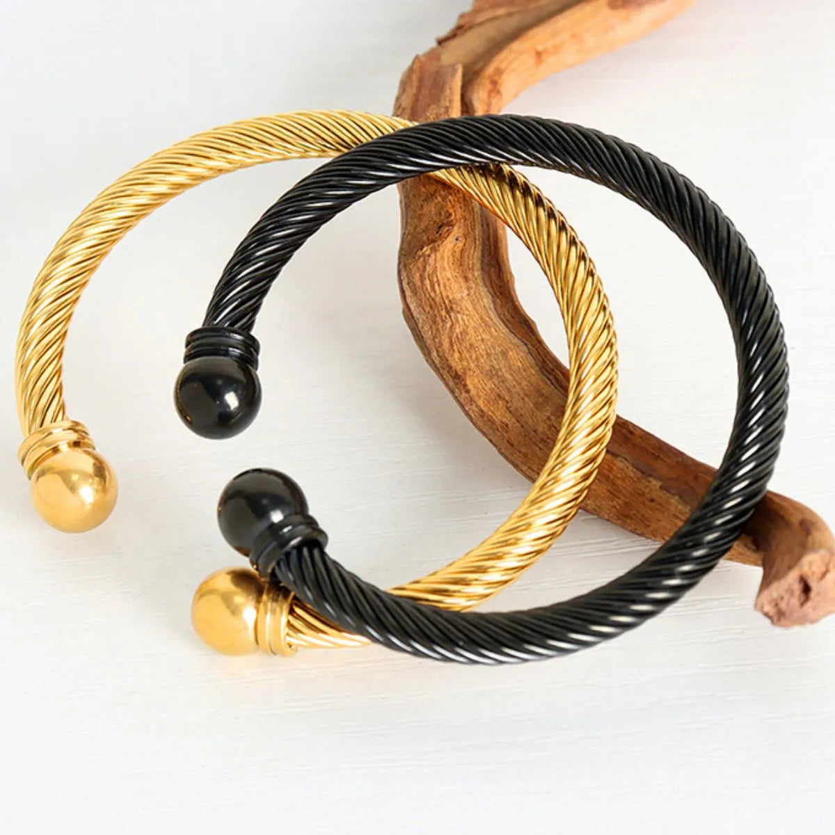 Gold and black wire bracelets on a white background