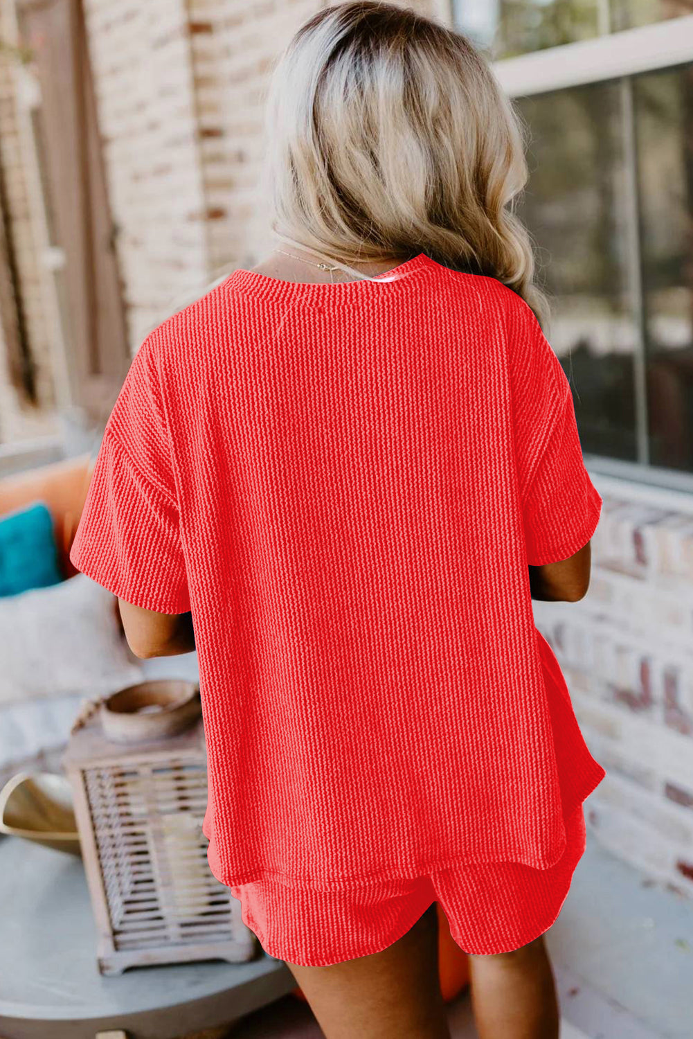 Person wearing a red outfit sitting on a bench outdoors.
