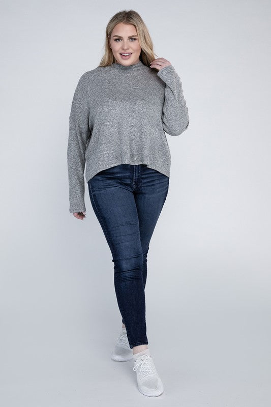 Woman wearing a gray sweater and blue jeans on a white background