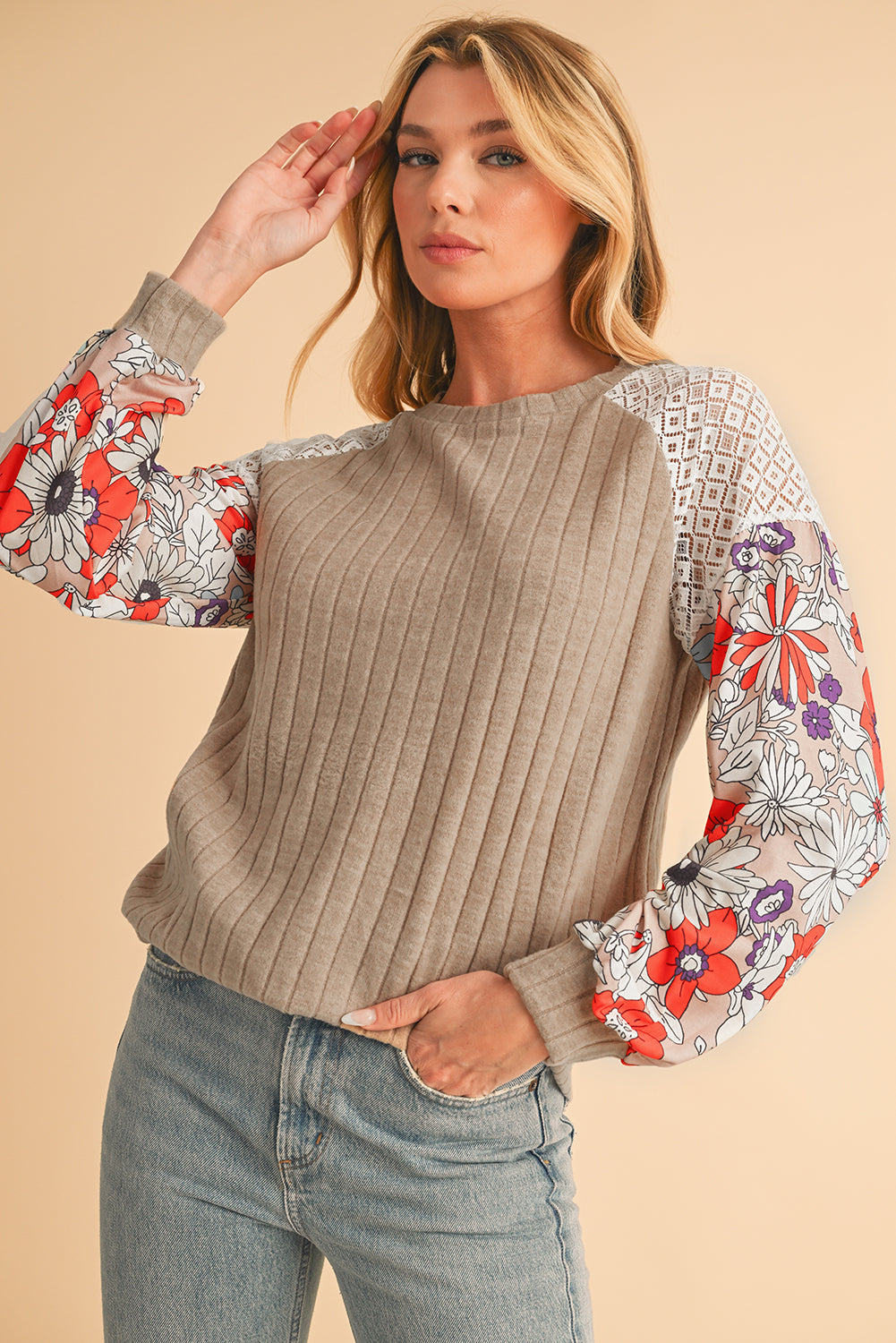 Woman wearing a beige sweater with floral sleeves on a beige background