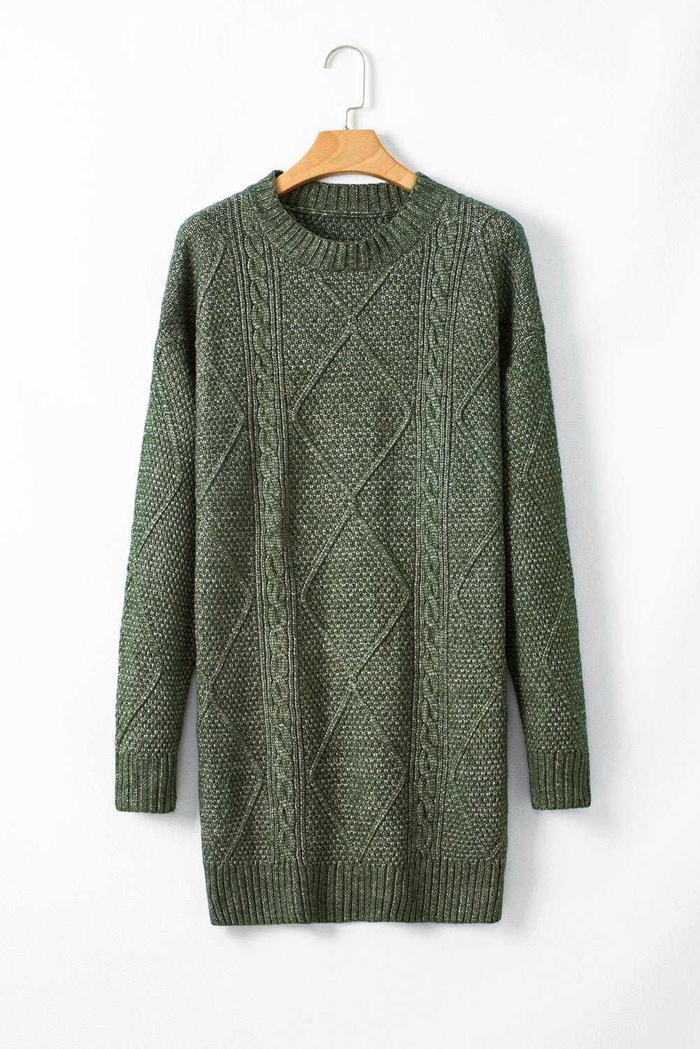 Green cable knit sweater on a wooden hanger against a white background