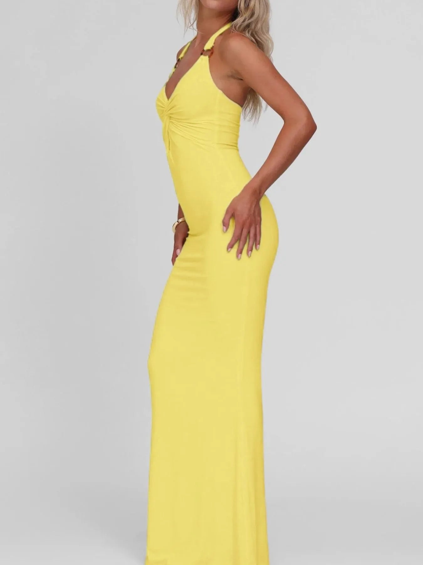 Yellow evening gown on a model against a plain background