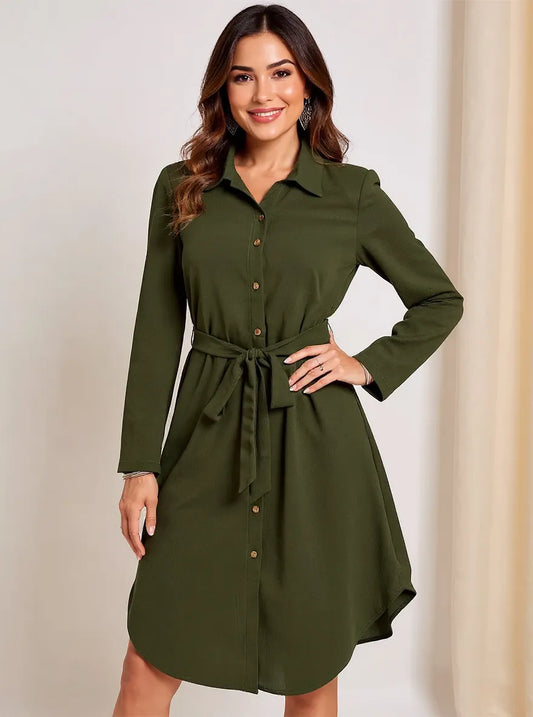 Woman wearing a green dress with a belt against a plain background