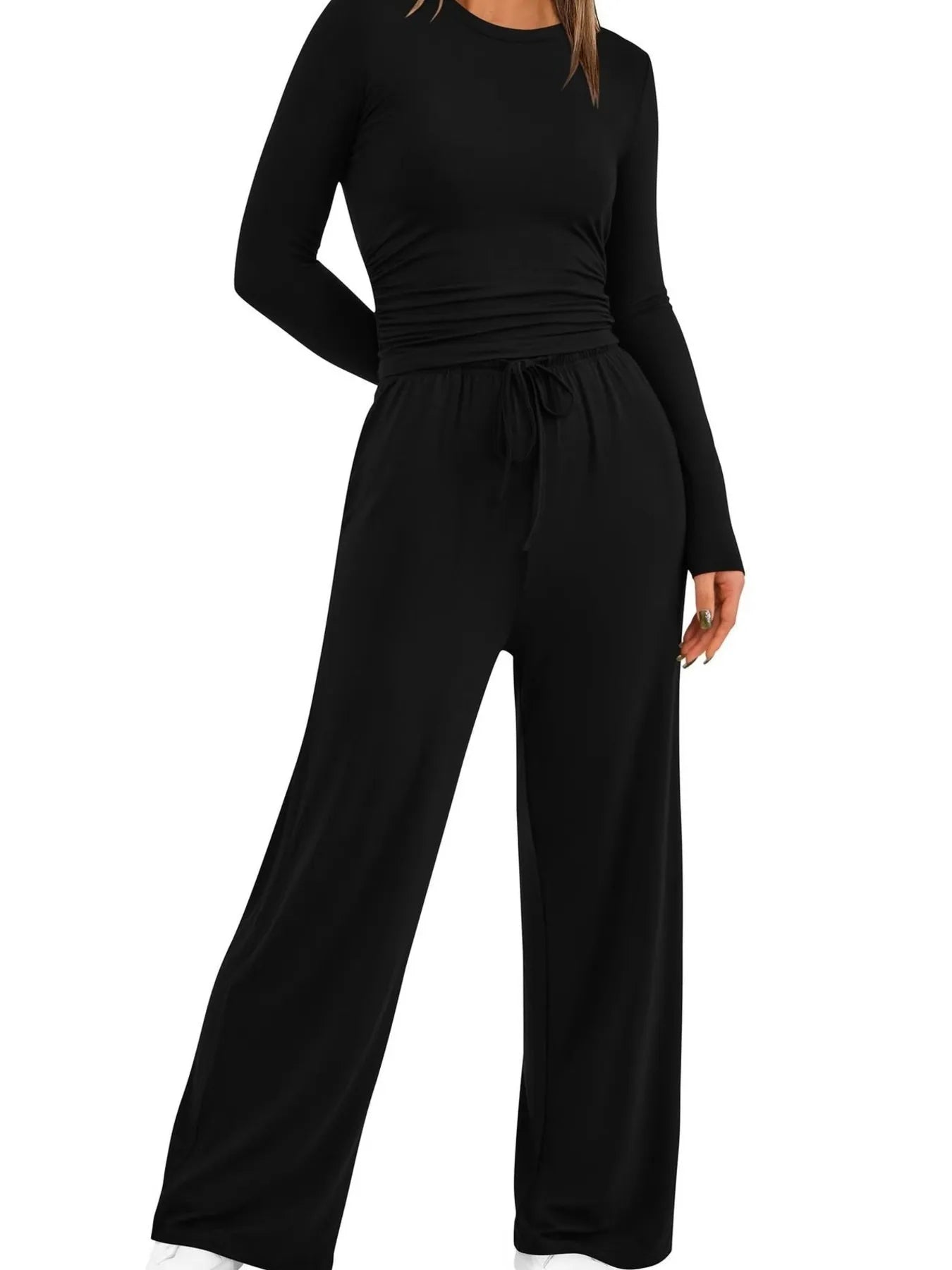 Black jumpsuit with long sleeves and wide-leg pants on a white background