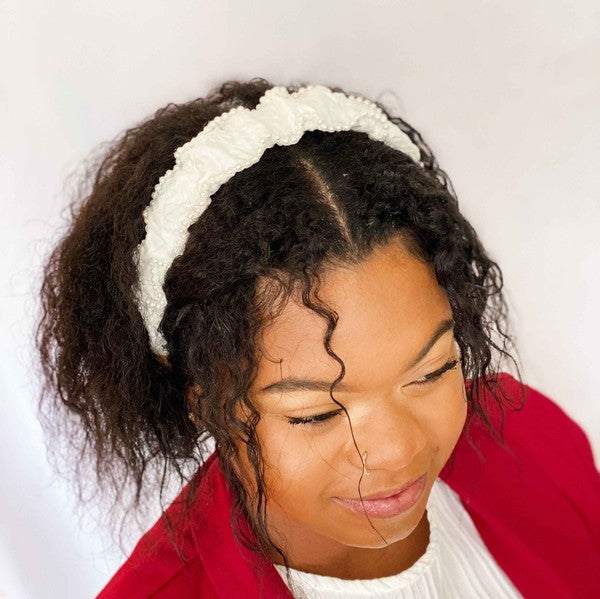 Woman wearing a white headband with a plain background