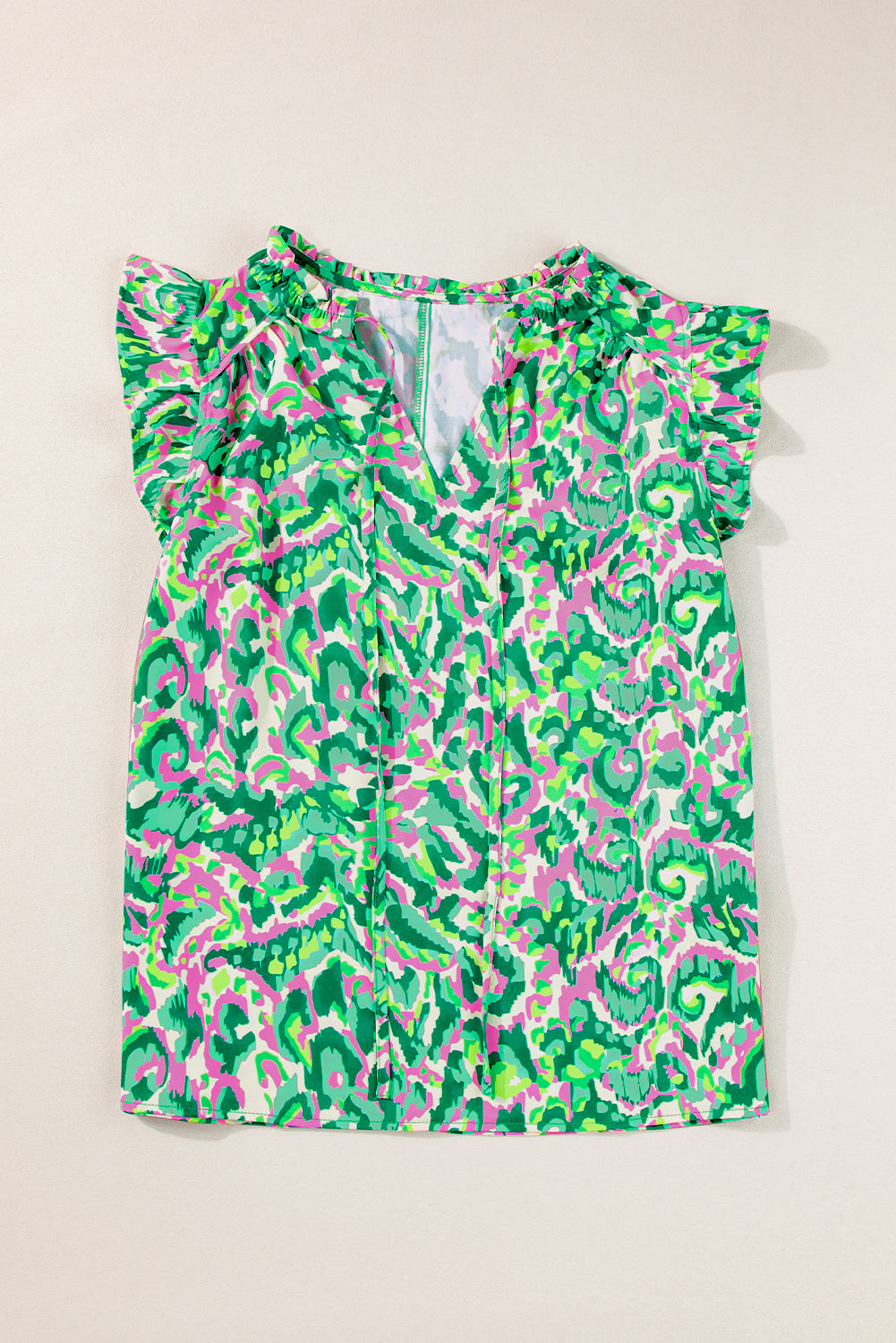 Green and pink patterned top on a beige background