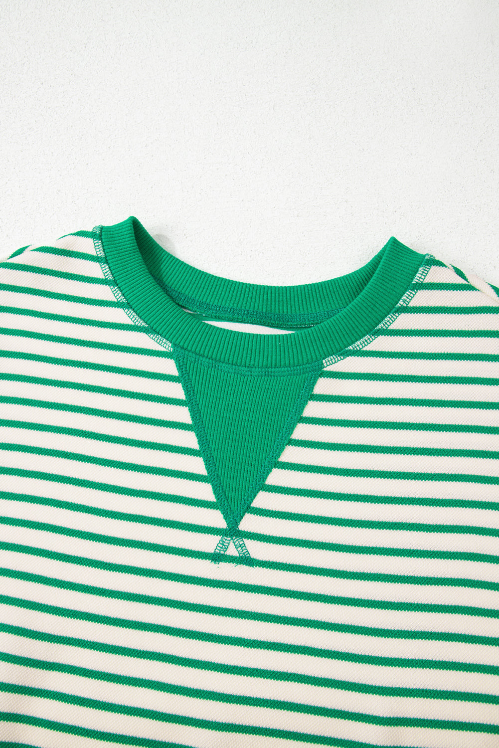 Green and white striped shirt with a close-up of the collar on a white background