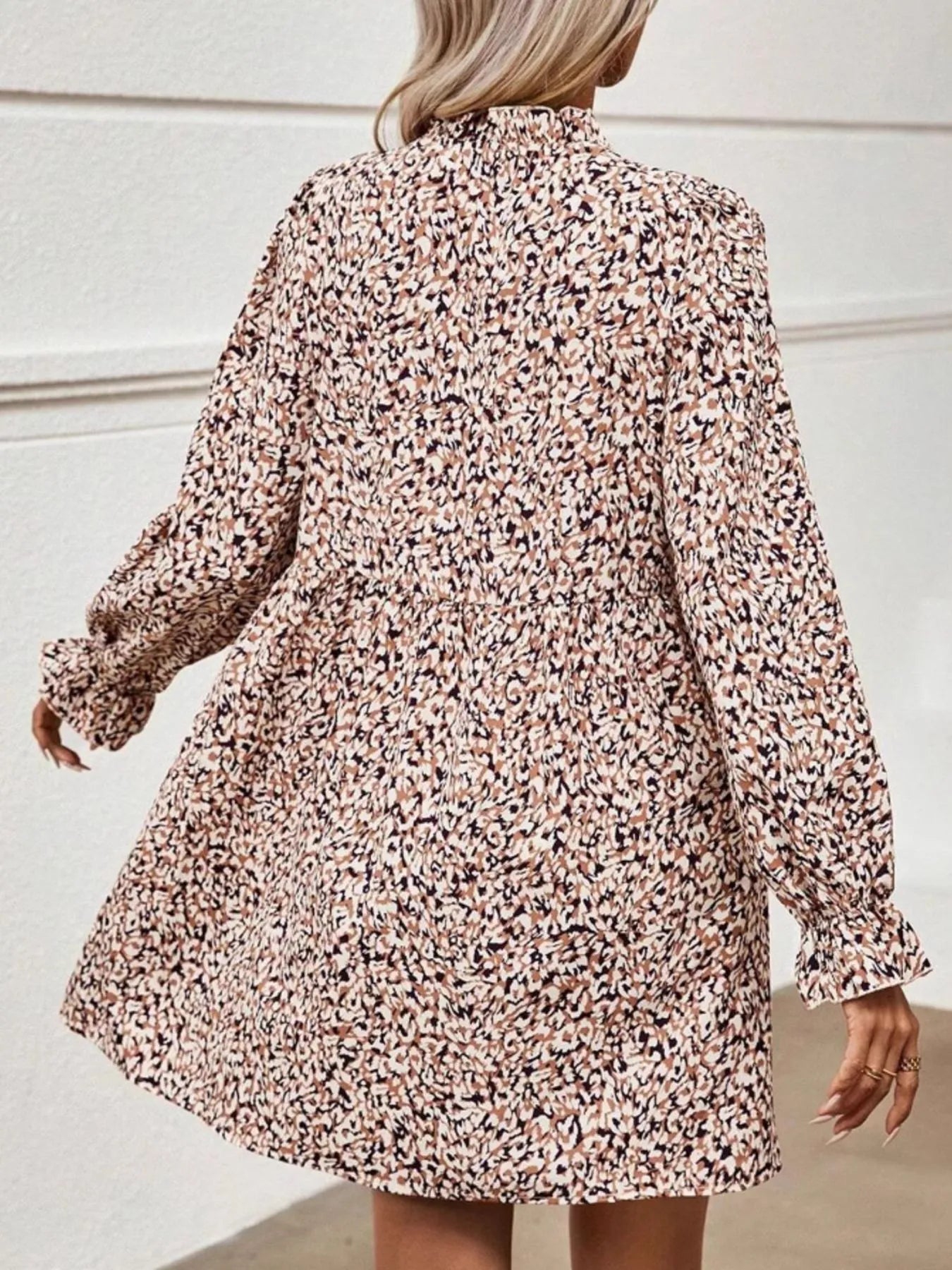 Floral patterned dress worn by a person against a neutral background