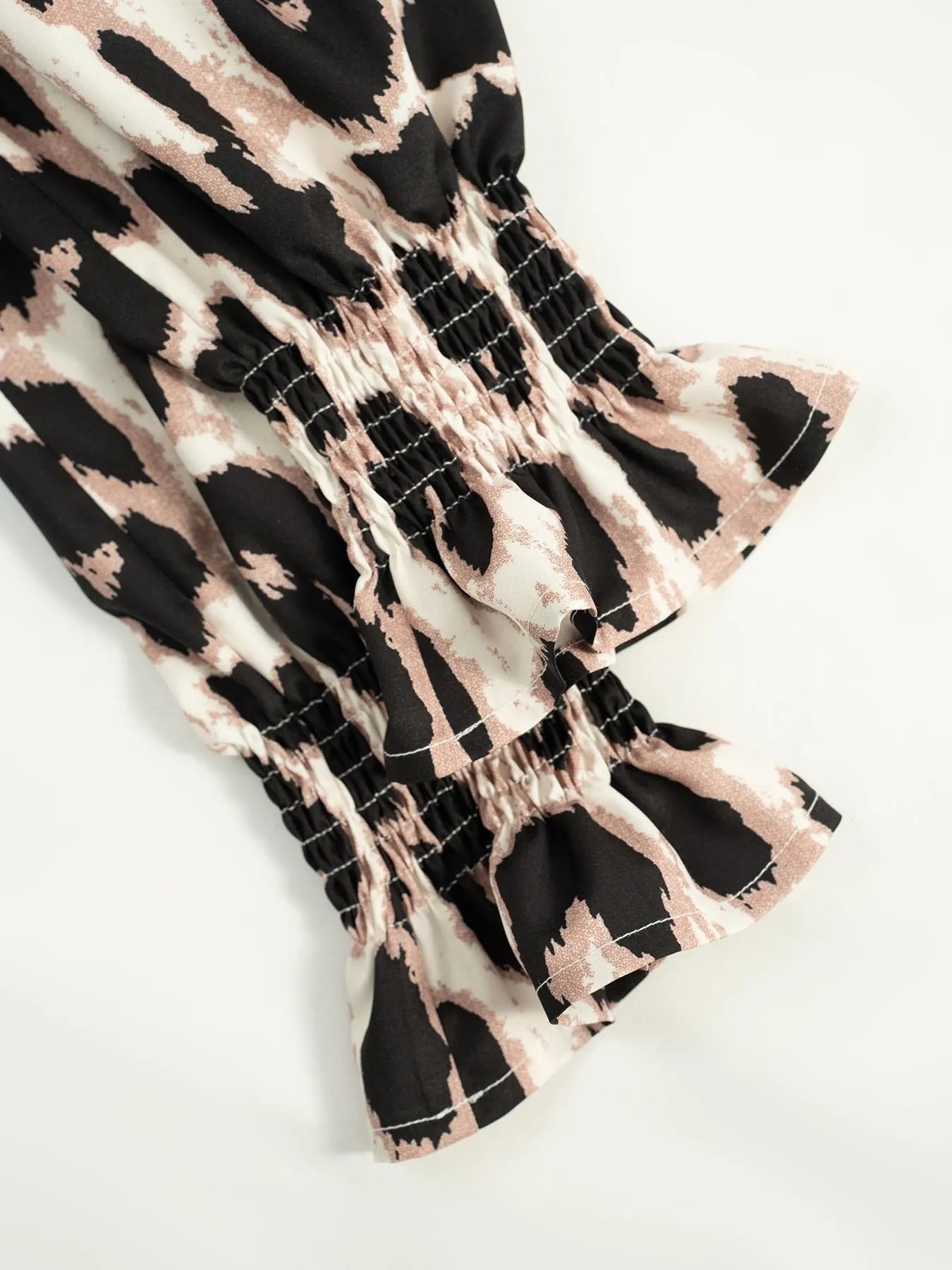 Close-up of a patterned fabric with black and beige design on a white background