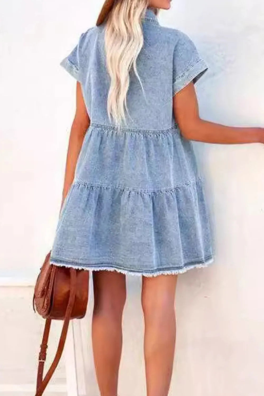 Woman wearing a denim dress with a plain background