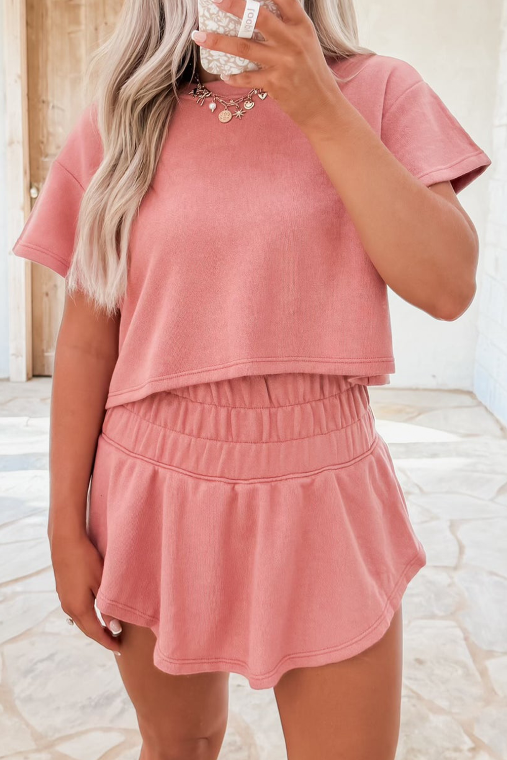 Person wearing a pink outfit with a matching top and skirt.
