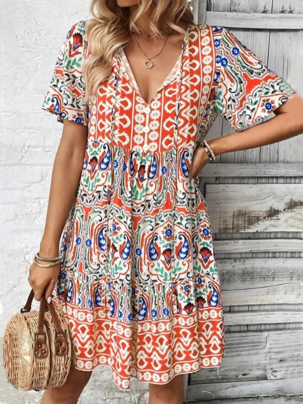 Woman wearing a colorful patterned dress against a wooden background