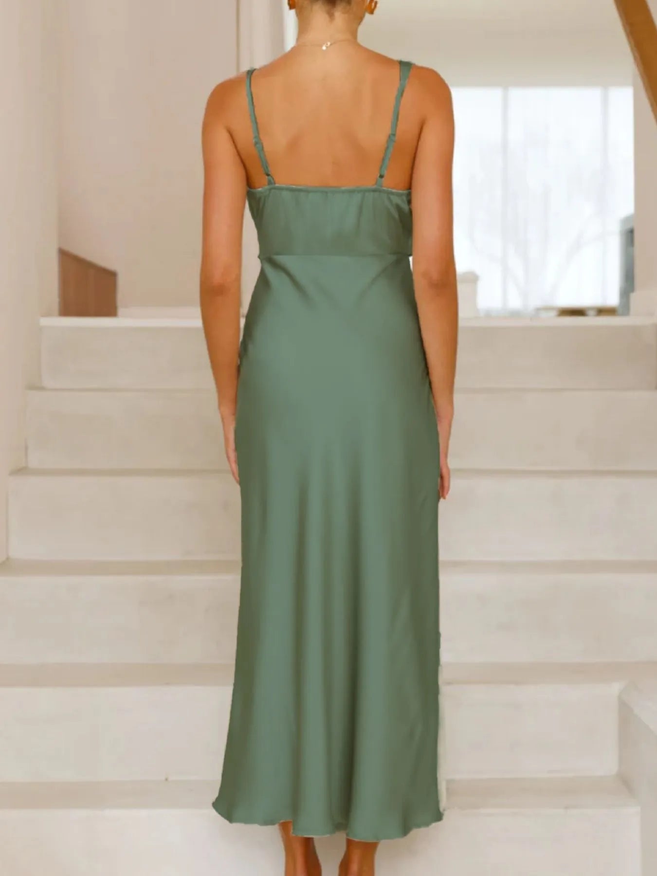 Woman wearing a green dress standing on a staircase
