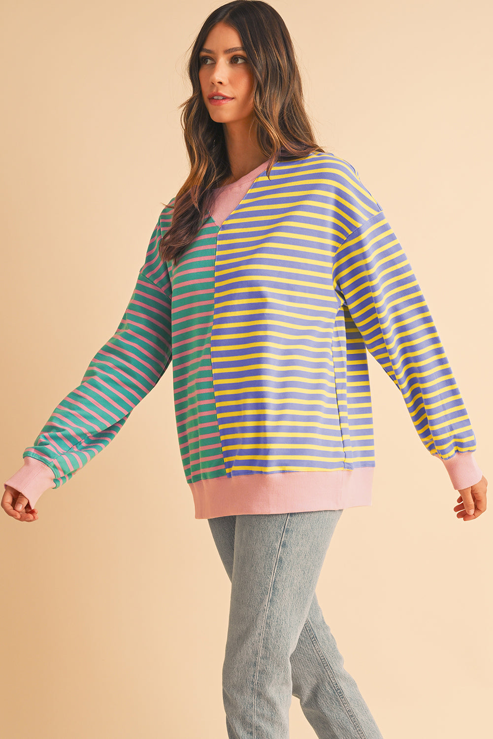 Woman wearing a colorful striped sweater on a beige background