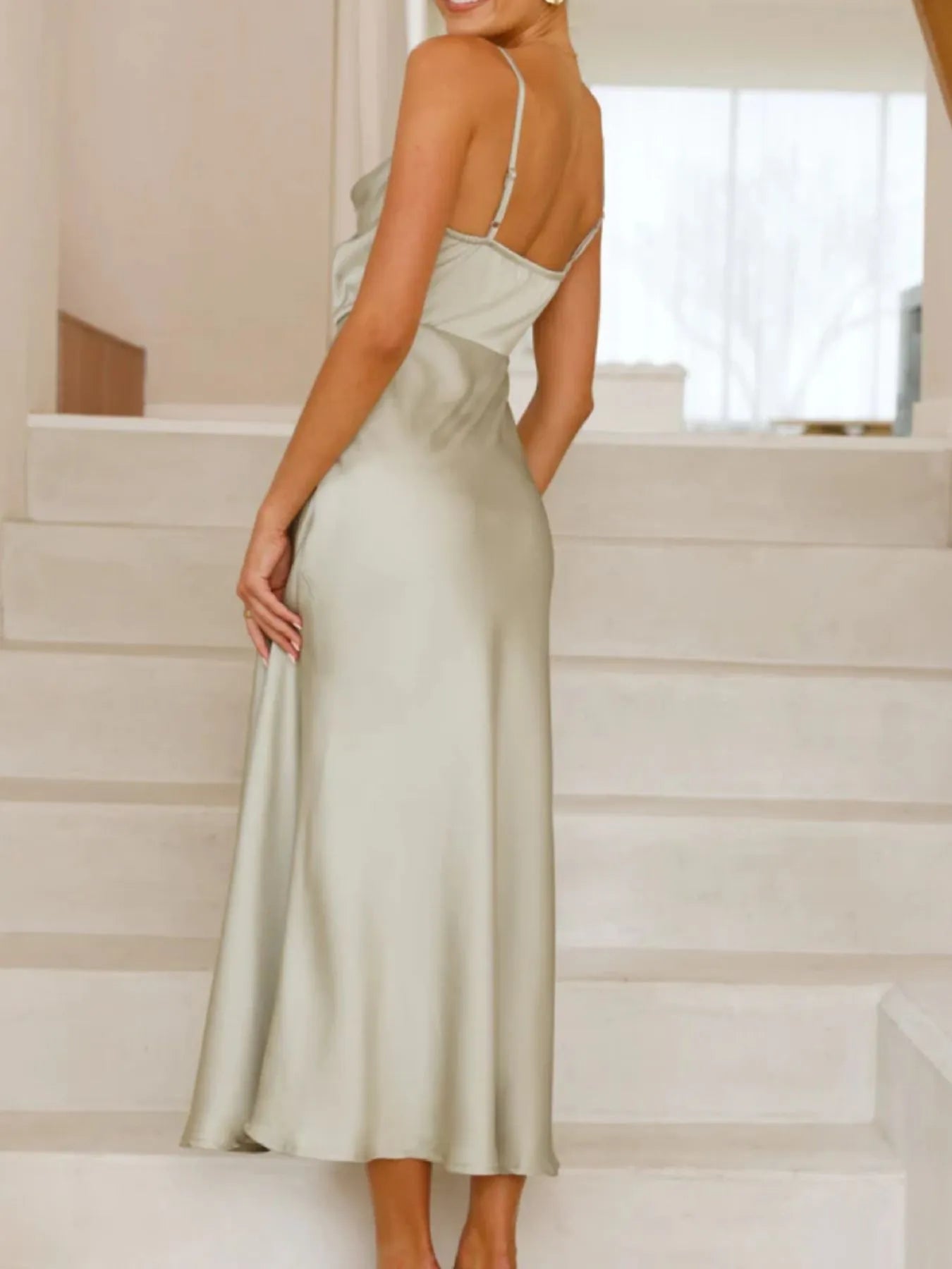Woman in a light green dress standing on a staircase