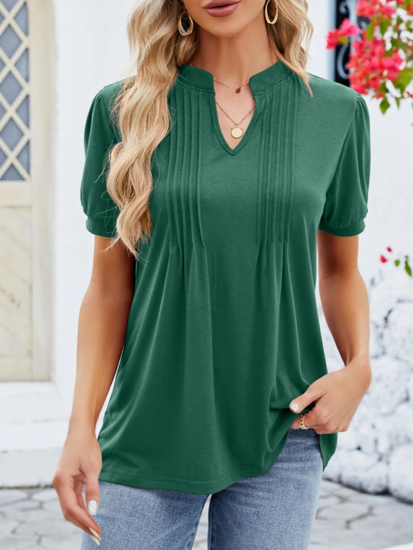 Woman wearing a green short-sleeve top with a blurred background