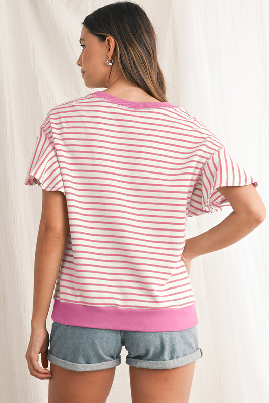 Woman wearing a pink and white striped shirt with a pink trim on a plain background