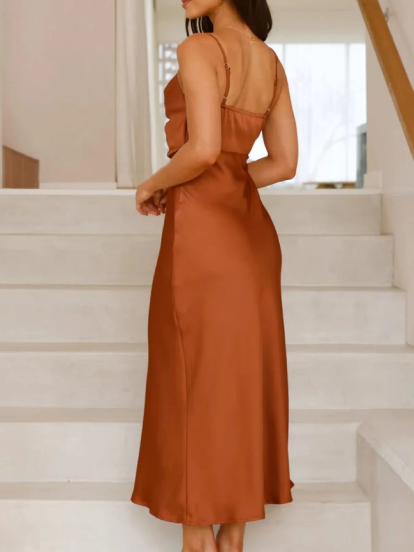 Woman in a rust-colored dress standing on a staircase