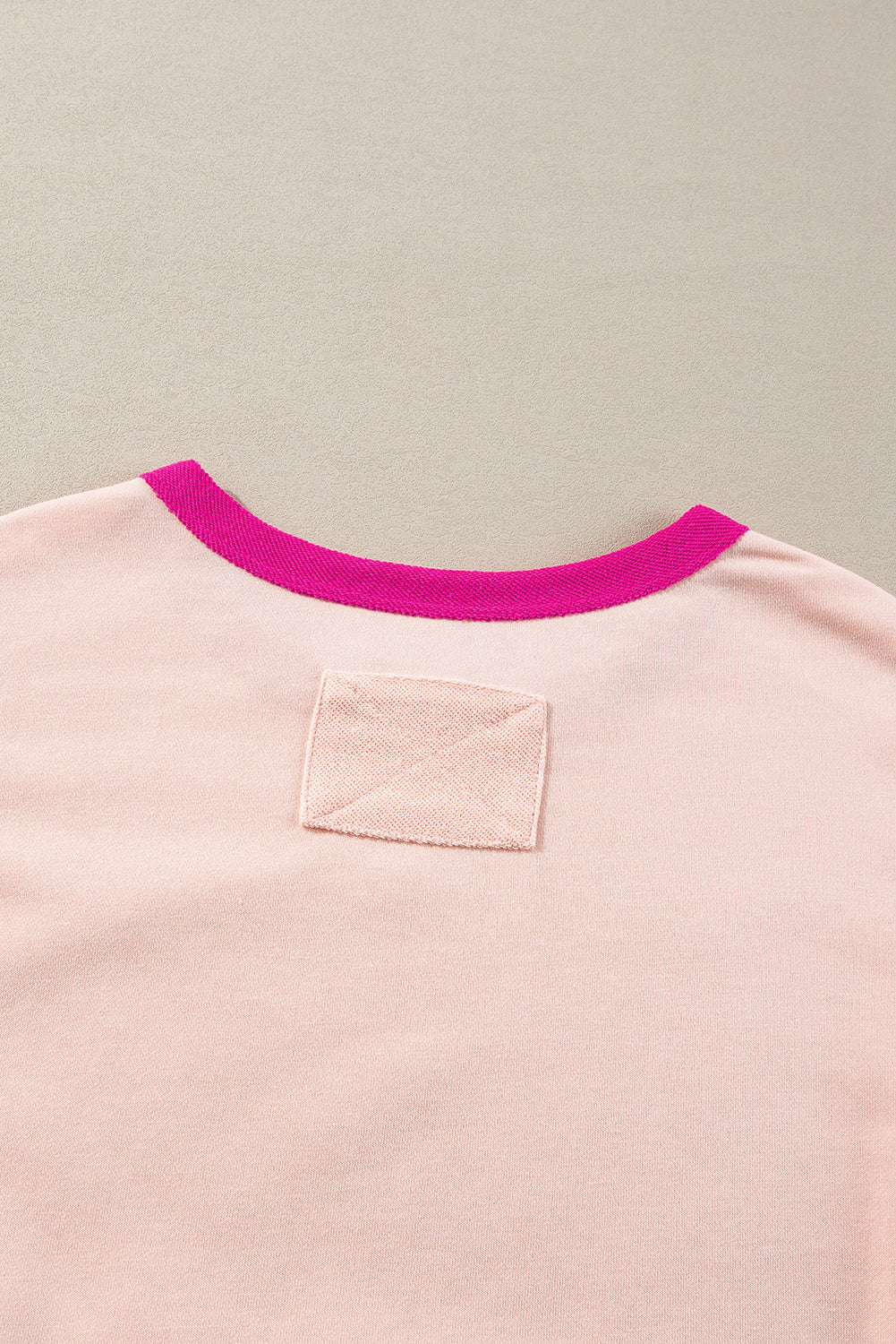 Pink shirt with a pink collar on a beige background