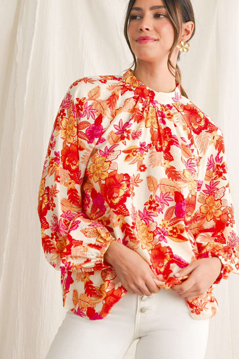 Woman wearing a colorful floral blouse against a white background