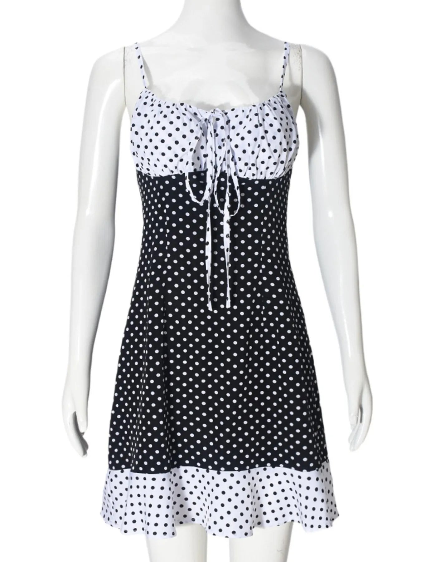 Black and white polka dot dress on a mannequin against a white background
