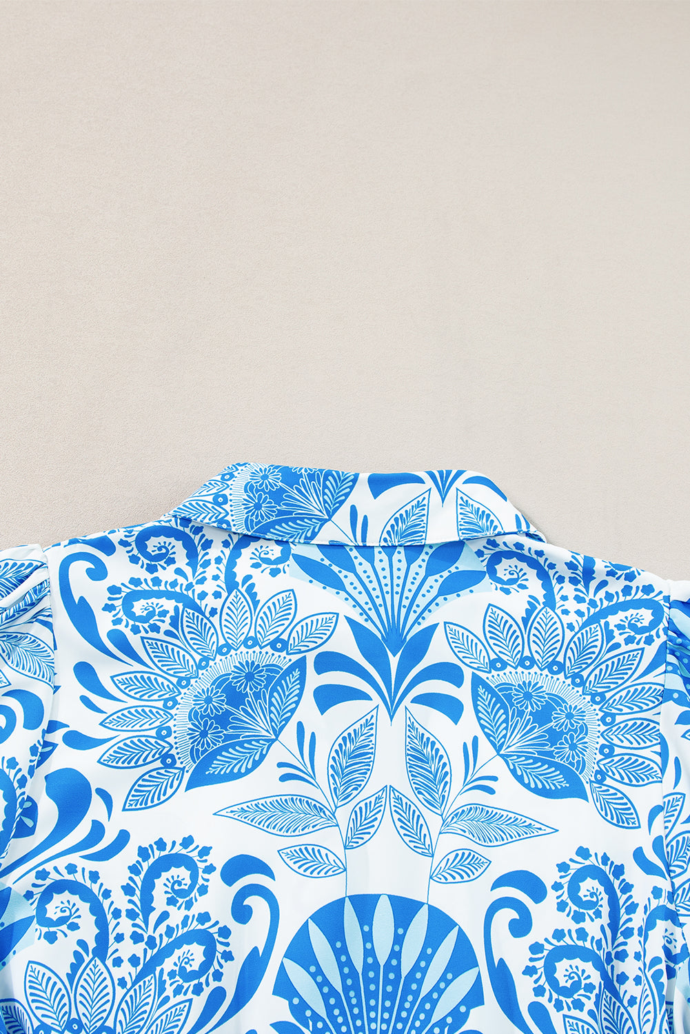 Blue floral pattern on a white shirt against a beige background