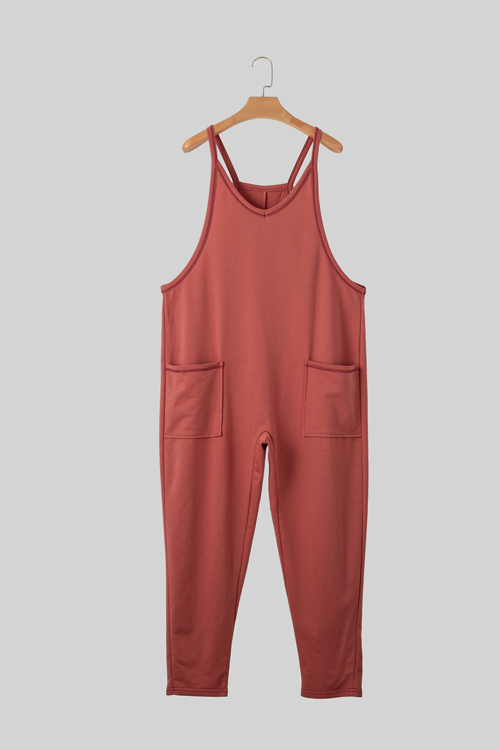 Red jumpsuit on a hanger against a gray background