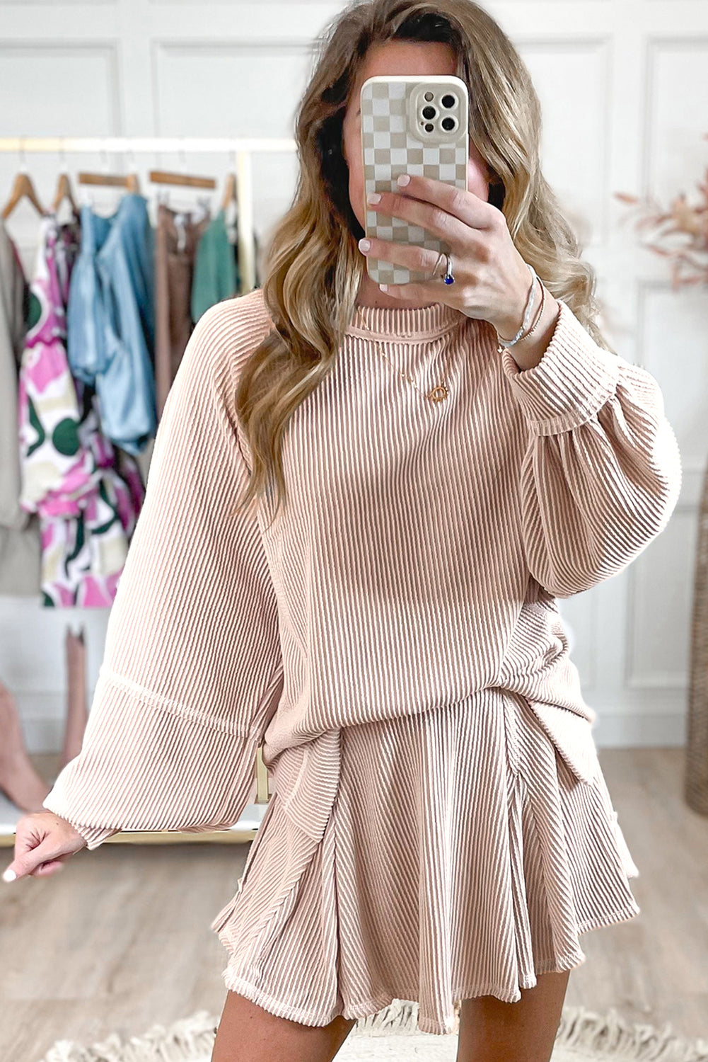Woman wearing a matching ribbed sweater and skirt set in a clothing store.