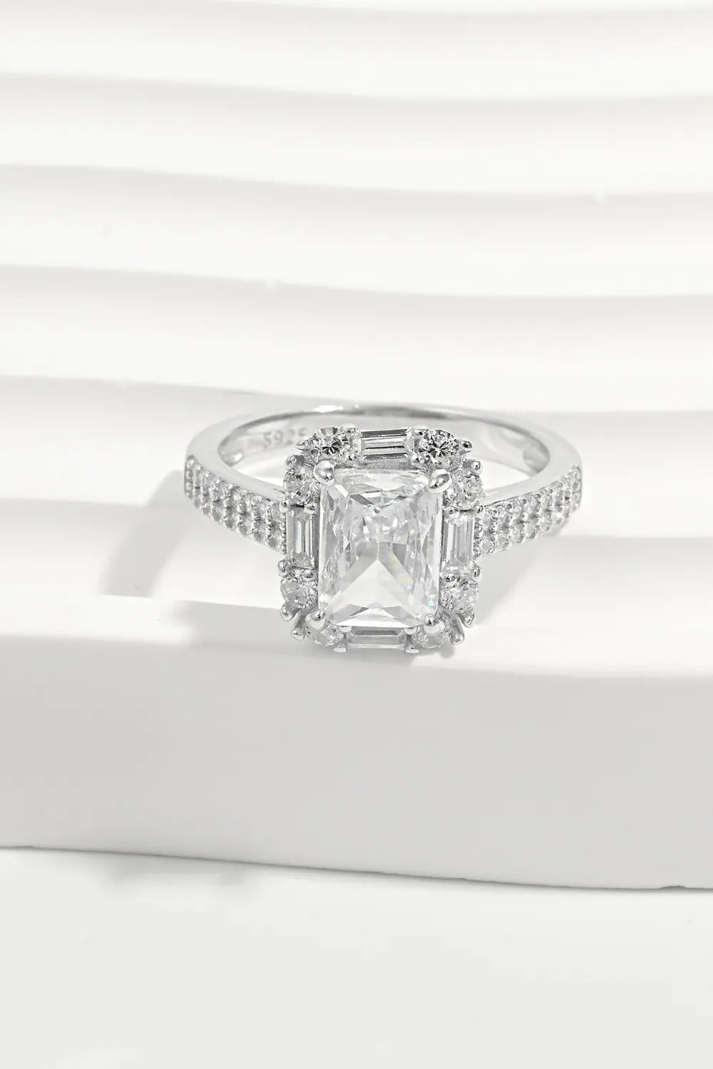 Diamond ring with a rectangular stone on a white surface